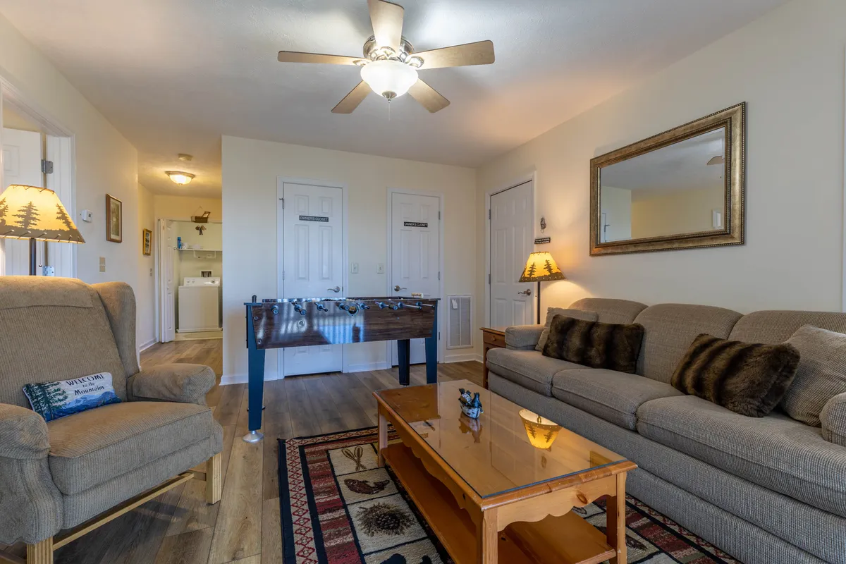 An inviting interior scene showcasing a foosball table, comfortable sofa, coffee table, and a decorative lamp. The area looks designed for family game nights, casual gatherings, and relaxation, with enough space for everyone to join in the fun.