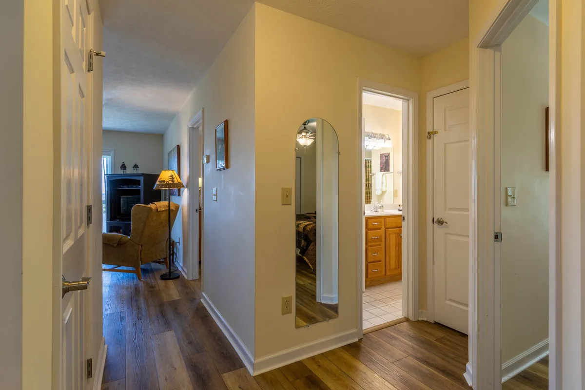 A comfortable seating area adjacent to a mirror and light fixture, with a visible entrance to a bathroom. The space feels inviting and encourages casual conversation, morning routines, or unwinding after a day of adventure.
